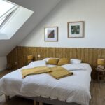 chambre avec draps blancs et coussins jaunes